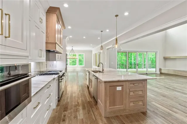 a view of a hallway with wooden floor and a bathroom