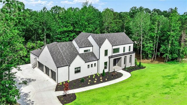 a white house with a yard and plants