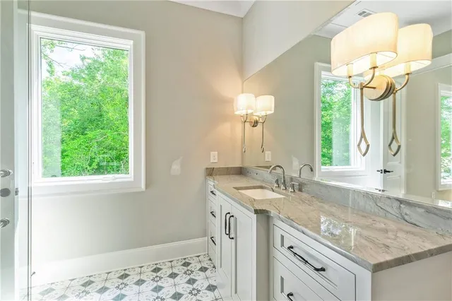 a bathroom with a granite countertop sink toilet and shower