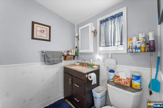 a utility room with fridge and wooden floor
