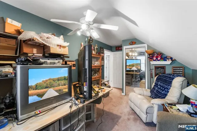 a living room with furniture a flat screen tv and a floor to ceiling window