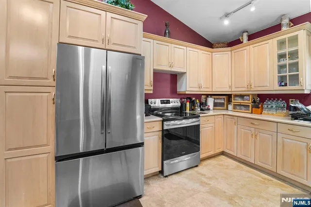 a kitchen with stainless steel appliances granite countertop a refrigerator a stove a sink and a microwave