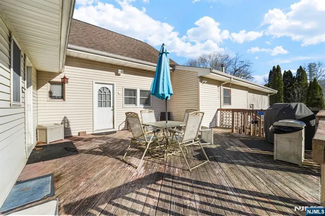 a view of a patio with table and chairs with wooden floor and fence