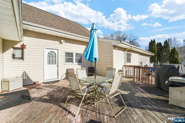 a view of a patio with table and chairs with wooden floor and fence