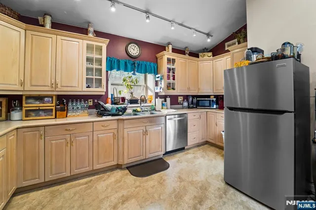 a kitchen with white cabinets and refrigerator