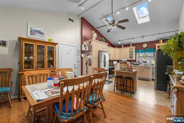 a dining room with wooden floor a chandelier a wooden table and chairs