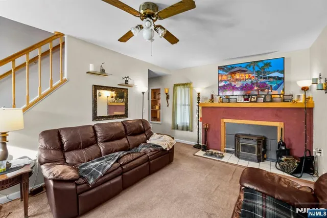 a living room with furniture a fireplace and a flat screen tv