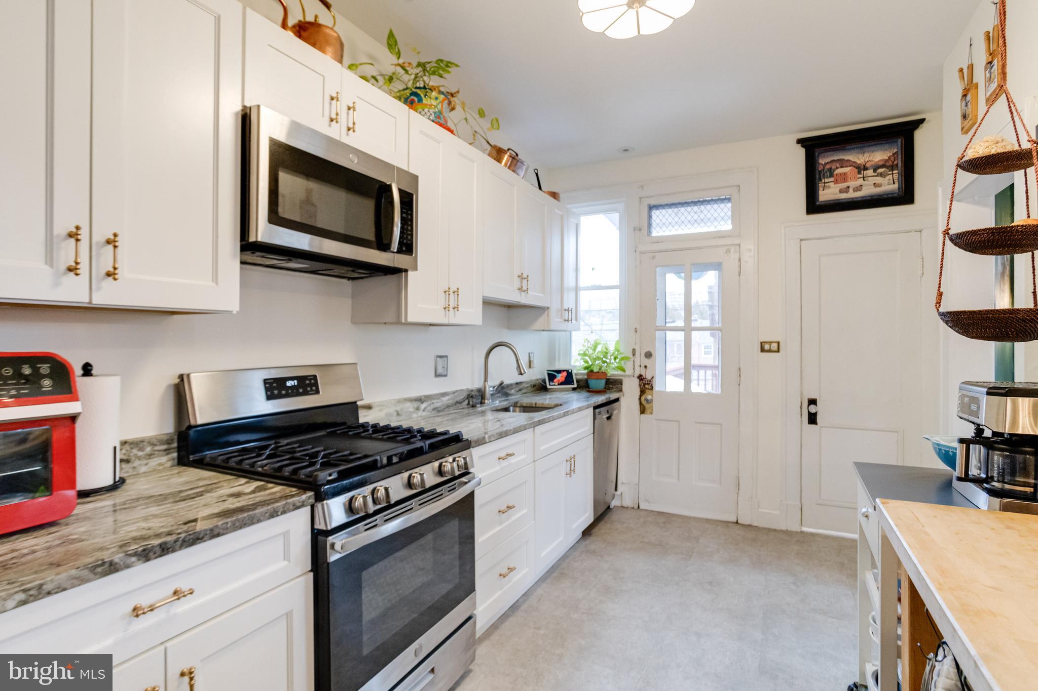 3901 Keswick Road Baltimore, MD 21211 - Photo 28 of 87 a kitchen with stainless steel appliances granite countertop a sink a stove a microwave and cabinets