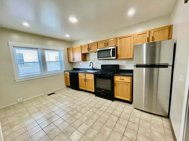 a kitchen with stainless steel appliances granite countertop a refrigerator sink stove microwave and cabinets