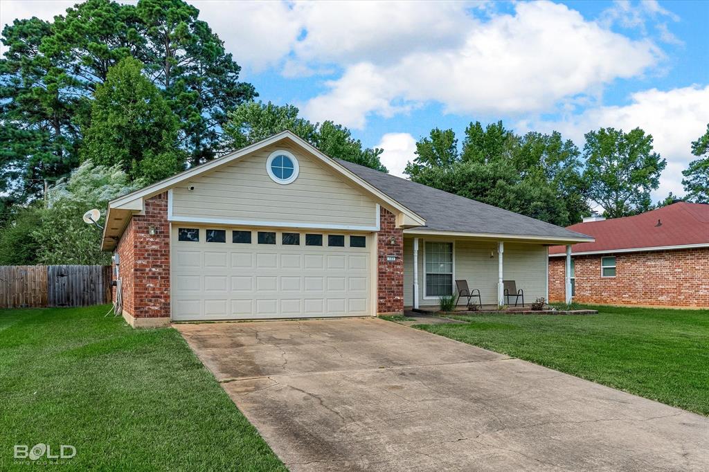 122 Ragan Lane Haughton, LA 71037 - Photo 29 of 34 Brick and siding exterior with an attached garage, a covered front porch, a concrete driveway, and a circular accent window