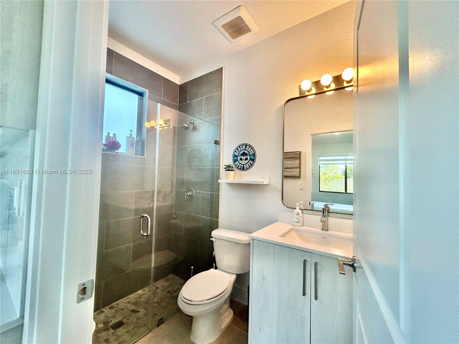 13281 Southwest 227th Street, Unit 1 Miami, FL 33170 - Photo 6 of 8 a bathroom with a sink toilet a mirror and shower