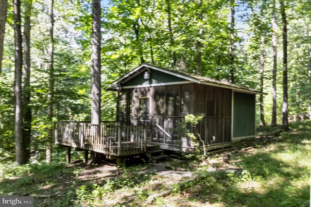 a view of an empty room with wooden floor and a ceiling fan