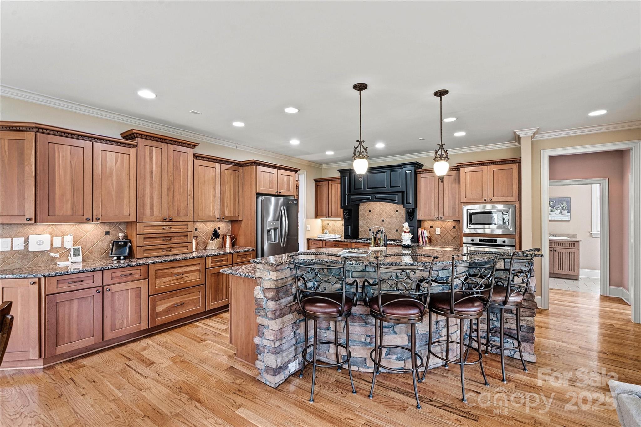 336 Kenway Loop Mooresville, NC 28117 - Photo 13 of 45 a kitchen with stainless steel appliances kitchen island granite countertop a table chairs sink and cabinets