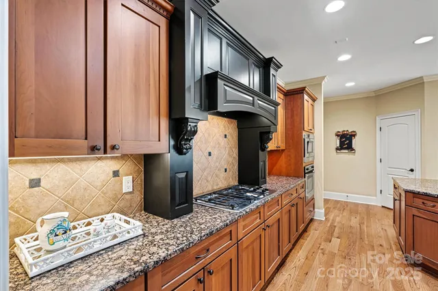 a kitchen with stainless steel appliances granite countertop a stove a sink and a refrigerator