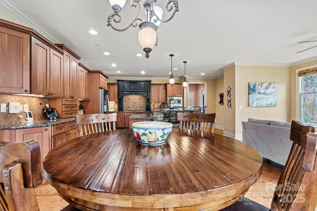 a dining room with wooden floor and large windows