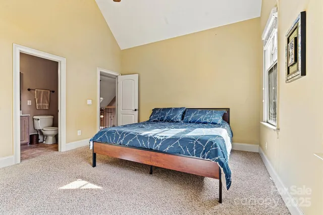 a bed sitting in a spacious bedroom next to a window