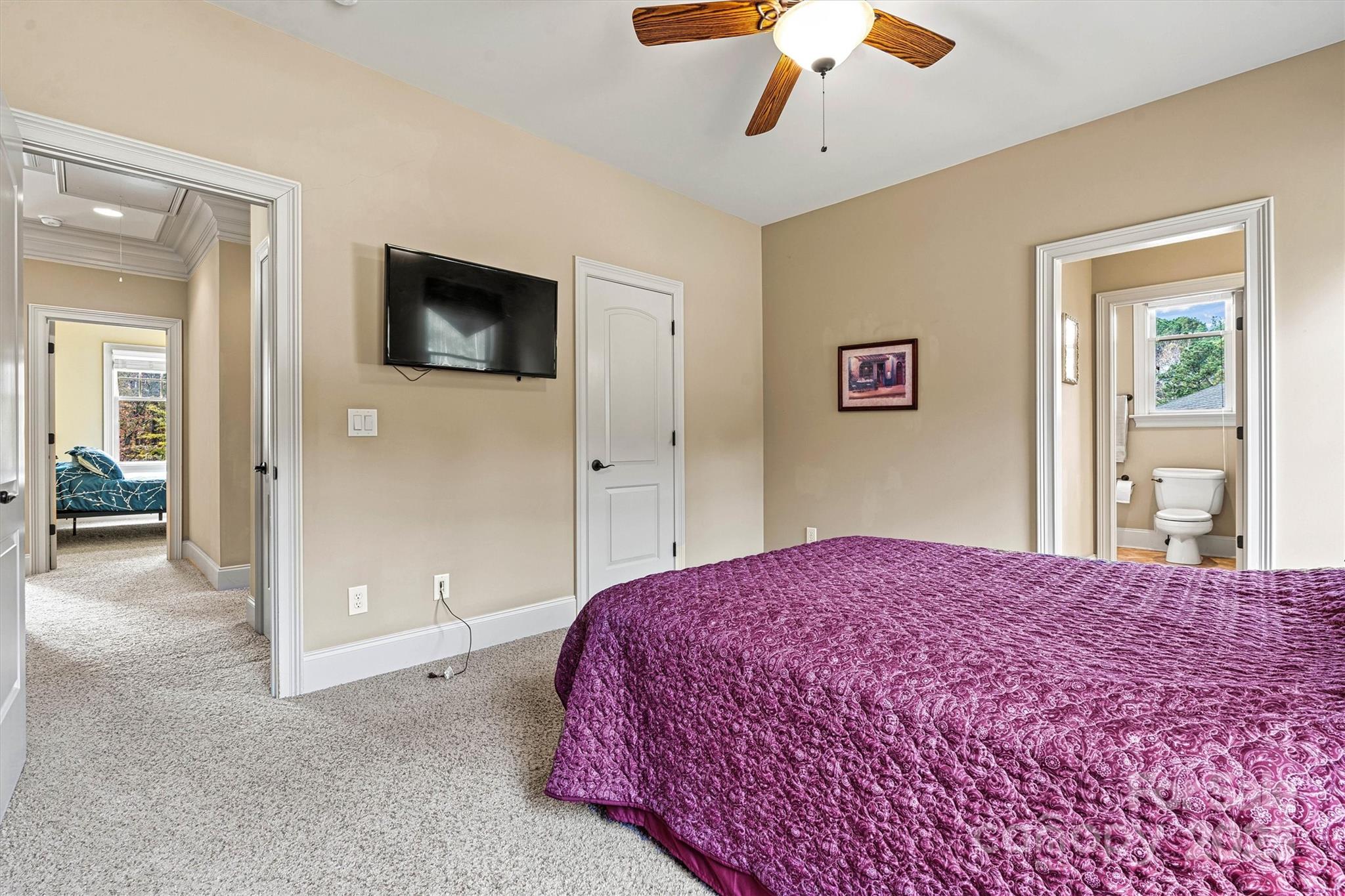 336 Kenway Loop Mooresville, NC 28117 - Photo 38 of 45 a bedroom with a large bed a flat tv screen and a chandelier