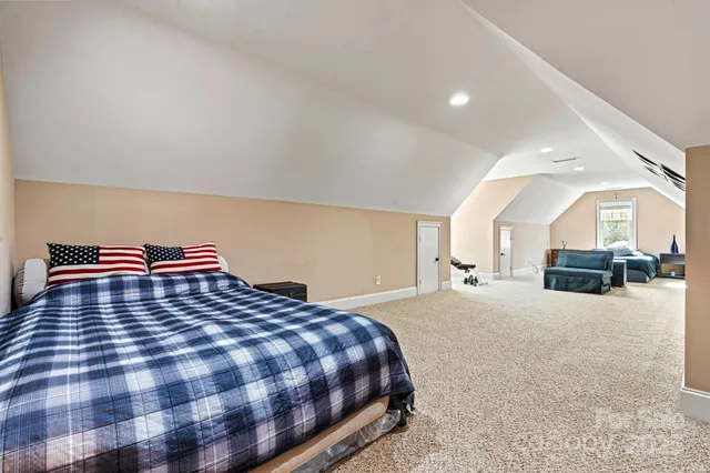 a large bedroom with a bed and window