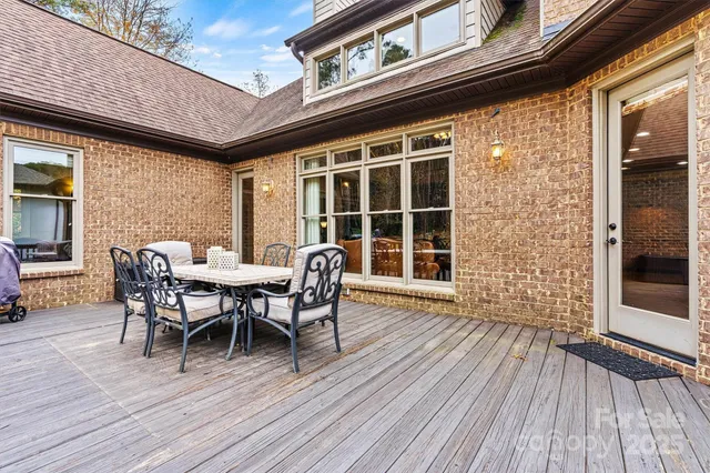 a view of a roof deck with table and chairs and wooden floor