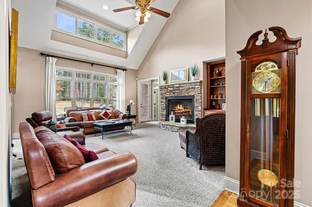 a living room with furniture a fireplace and a chandelier