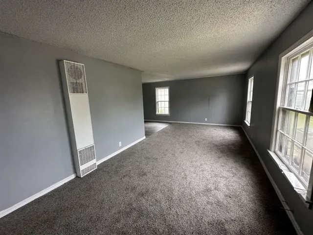 an empty room with windows and stairs