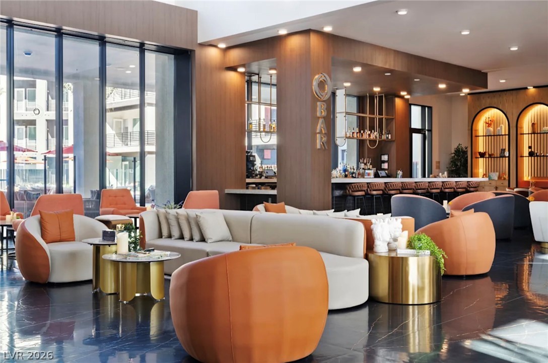 5050 West Russell Road, Unit 121 Las Vegas, NV 89118 - Photo 5 of 6 Gleaming stone flooring and soaring floor-to-ceiling windows define this expansive resident lounge and wet bar.