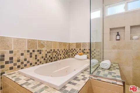 a bathroom with a granite countertop bathtub and shower