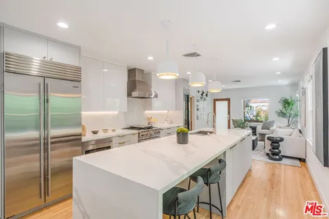 a large kitchen with kitchen island a large counter top space a sink stainless steel appliances and cabinets
