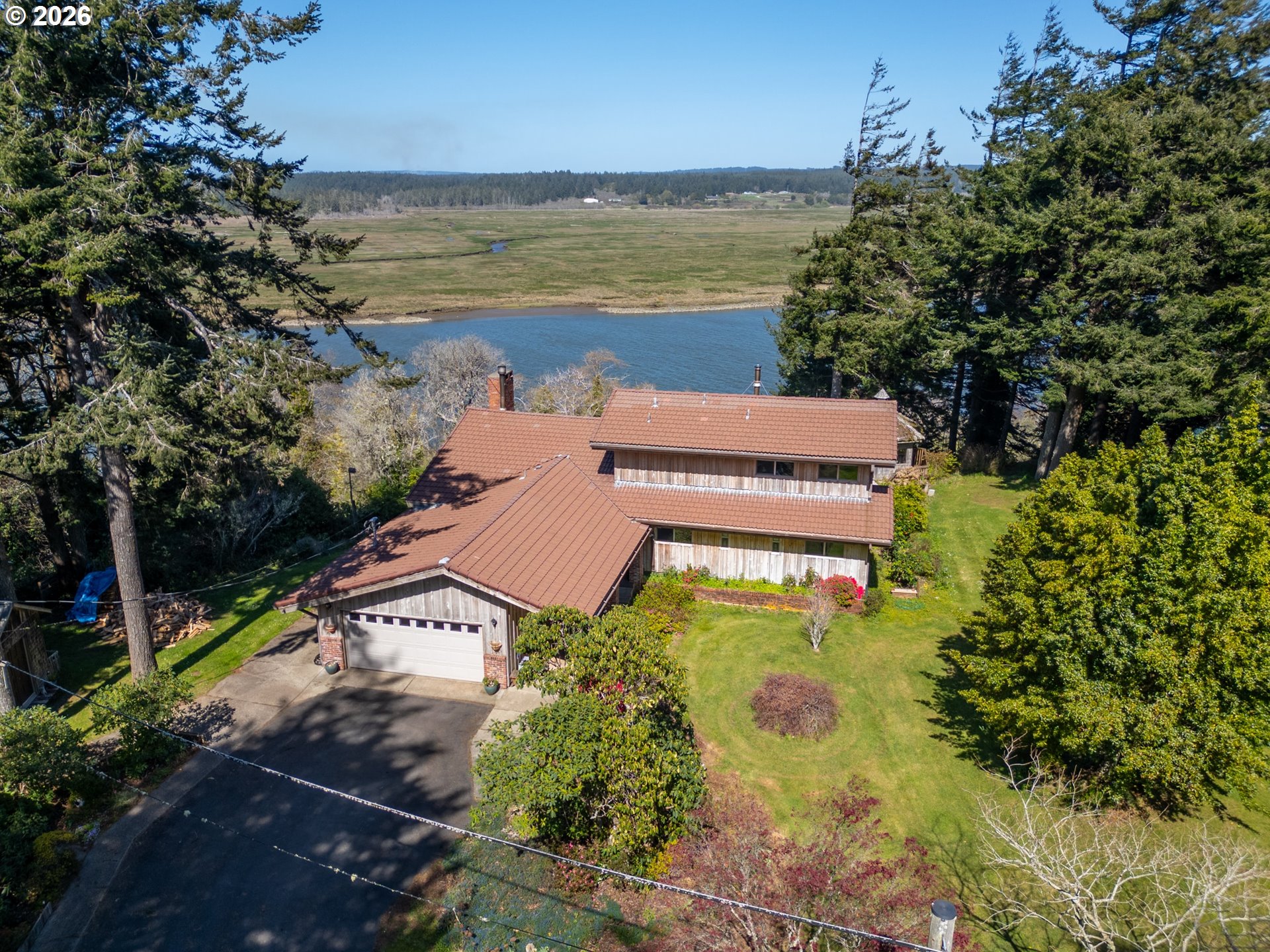 an aerial view of a house with a garden and lake view