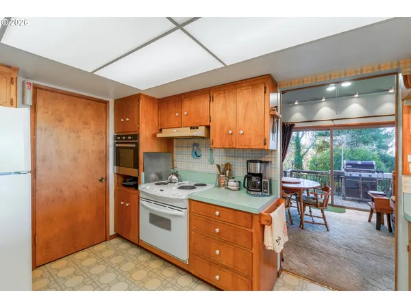 a kitchen with a stove a refrigerator and wooden floor