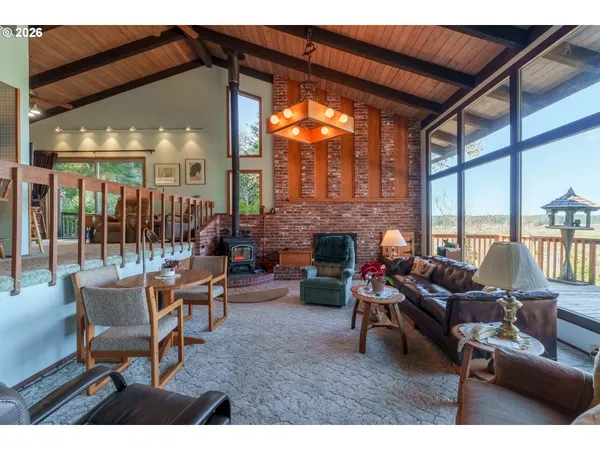 a living room with furniture a fireplace and floor to ceiling windows