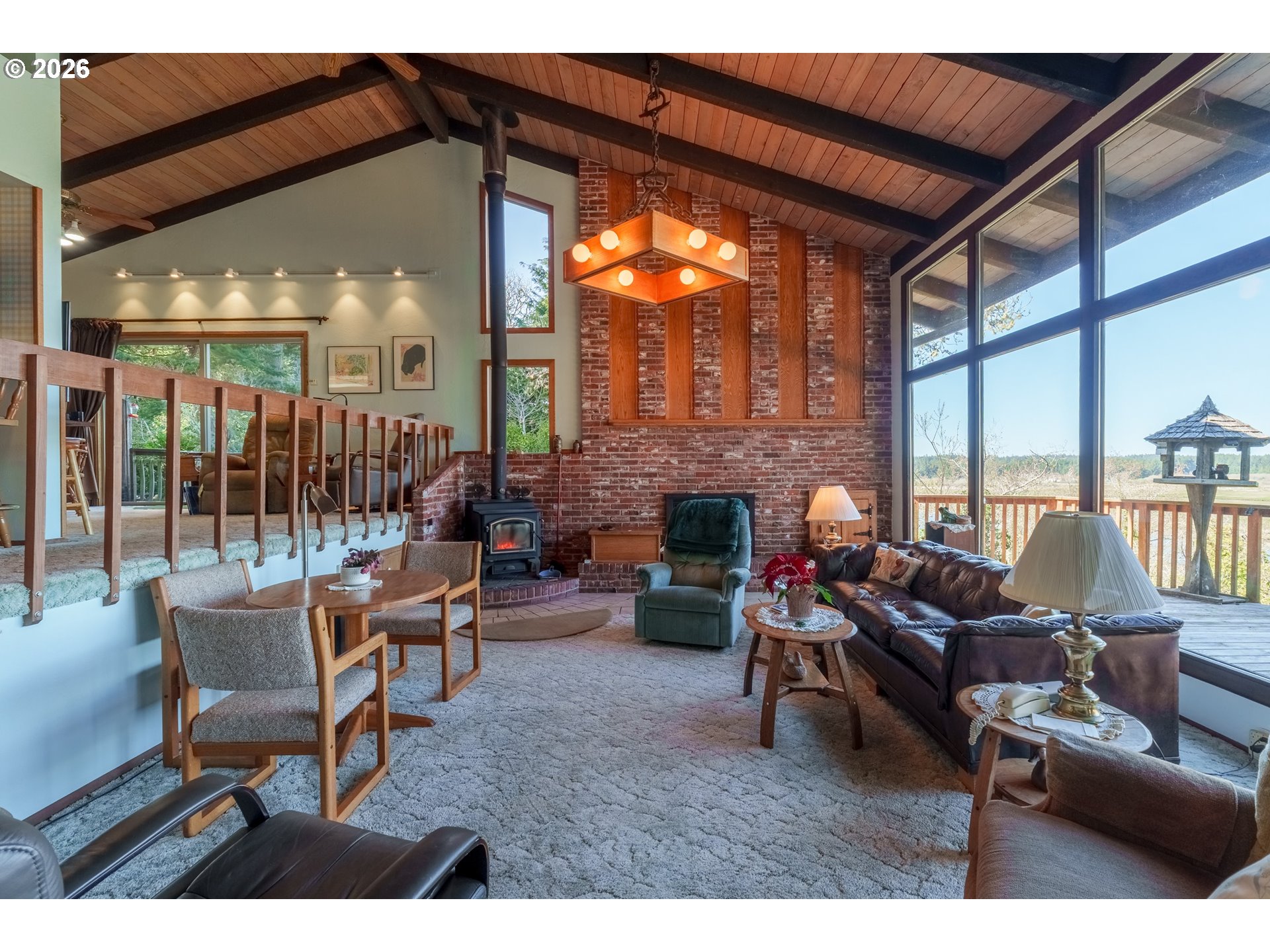 56358 Rusty Road Bandon, OR 97411 - Photo 20 of 41 a living room with furniture a fireplace and floor to ceiling windows