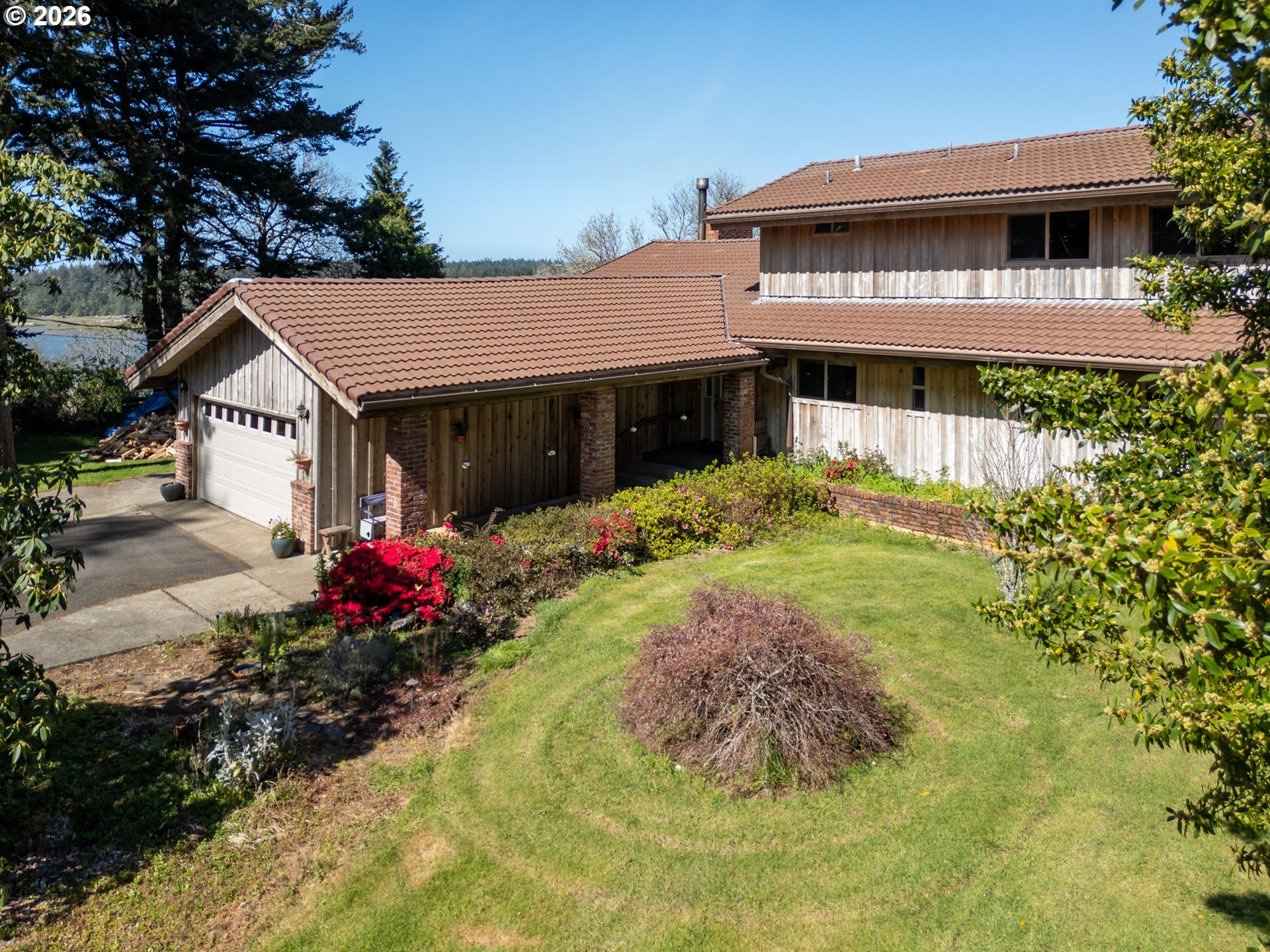 56358 Rusty Road Bandon, OR 97411 - Photo 3 of 41 a view of a house with a yard and potted plants