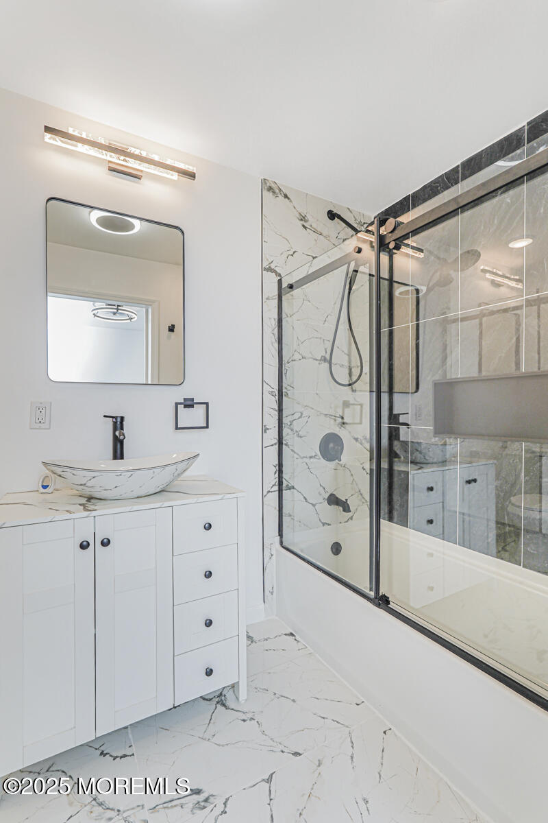 503 Ridge Avenue Neptune Township, NJ 07753 - Photo 16 of 17 a bathroom with a shower sink and mirror