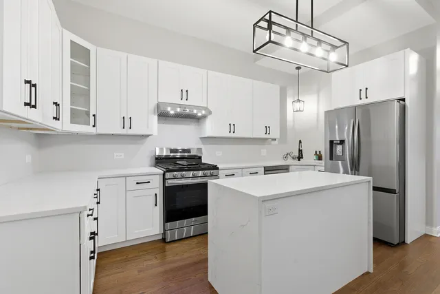 a kitchen with stainless steel appliances and white cabinets