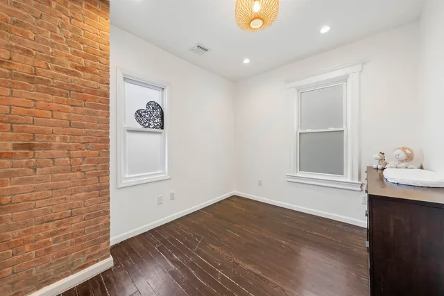 a view of a hallway with wooden floor and a window