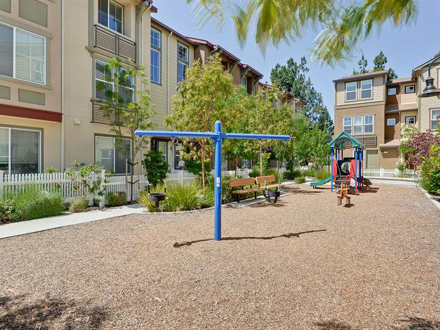247 Peppermint Tree Terrace, Unit 3 Sunnyvale, CA 94086 - Photo 24 of 25 a view of a street with potted plants and palm trees