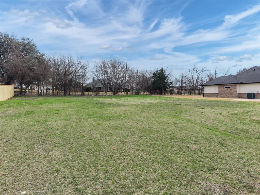 a view of a field with of trees in front of it