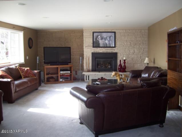 1551 Lombard Loop Road Wapato, WA 98951 - Photo 2 of 16 a living room with furniture a flat screen tv and a fireplace