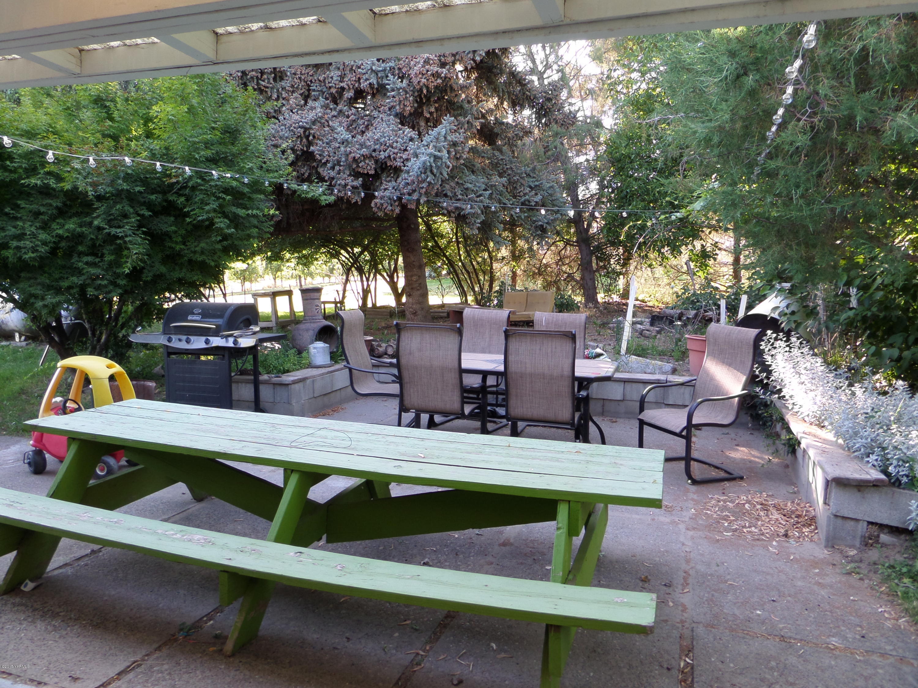 1551 Lombard Loop Road Wapato, WA 98951 - Photo 16 of 16 a view of backyard with seating area and trees in the background