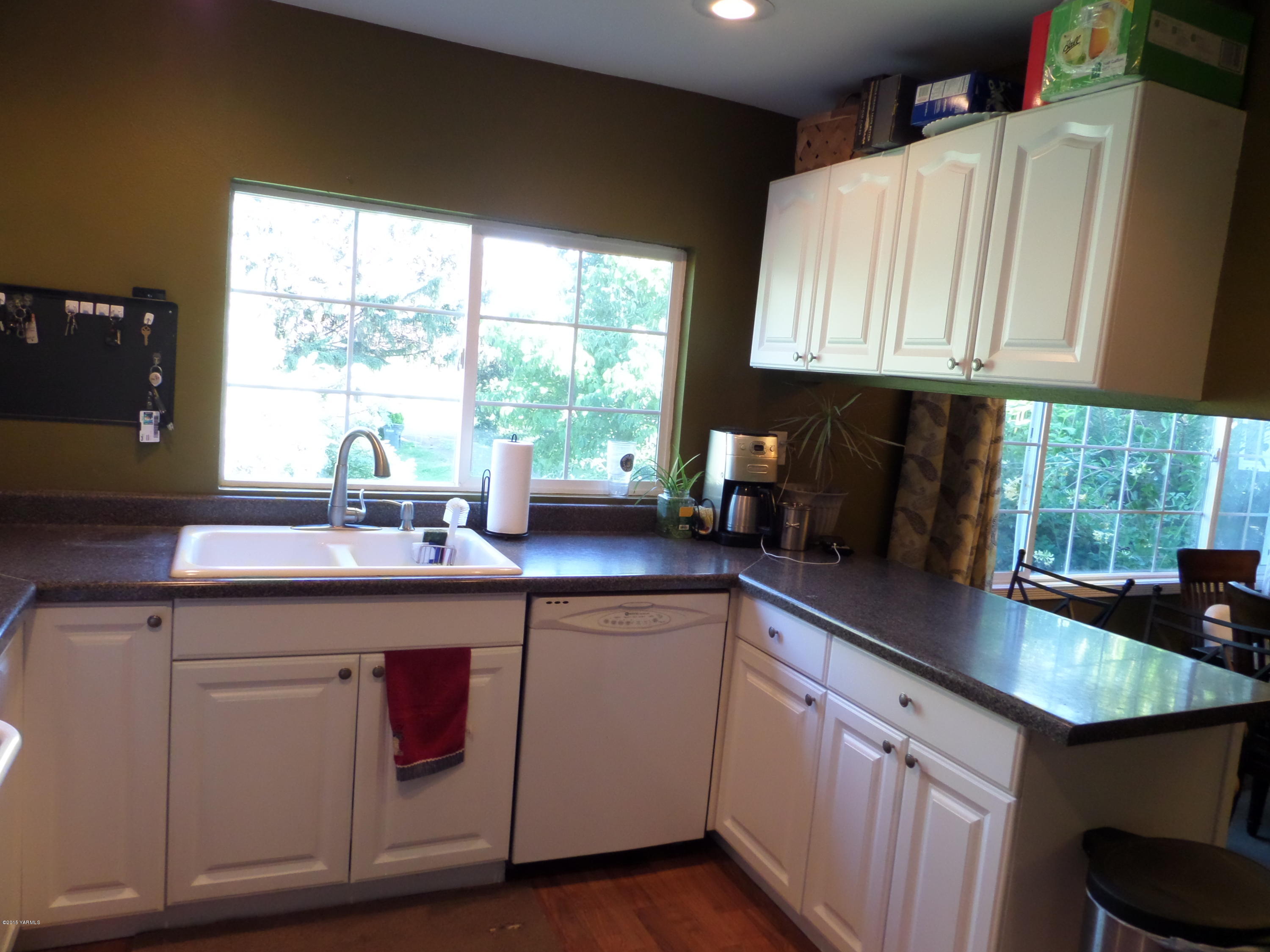 1551 Lombard Loop Road Wapato, WA 98951 - Photo 5 of 16 a kitchen with a sink a window and cabinets
