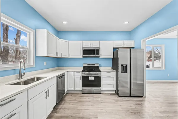 a kitchen with a sink stainless steel appliances and cabinets