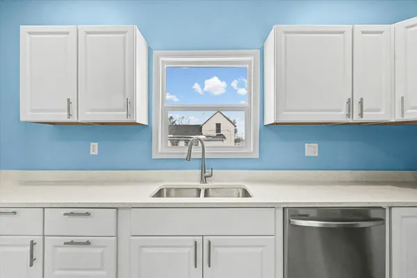 a kitchen with white cabinets and a sink