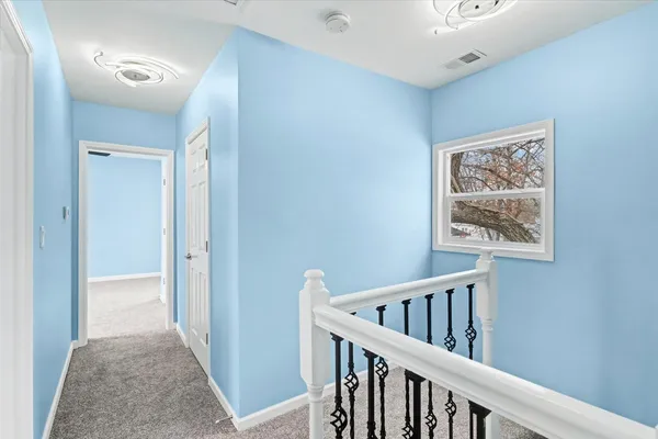 a view of a hallway with wooden floor and windows