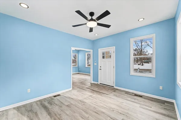 a view of wooden floor and a chandelier fan in a room