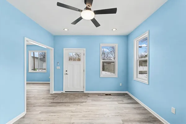 a view of an empty room with window and wooden floor