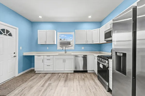 a kitchen with granite countertop white cabinets and stainless steel appliances
