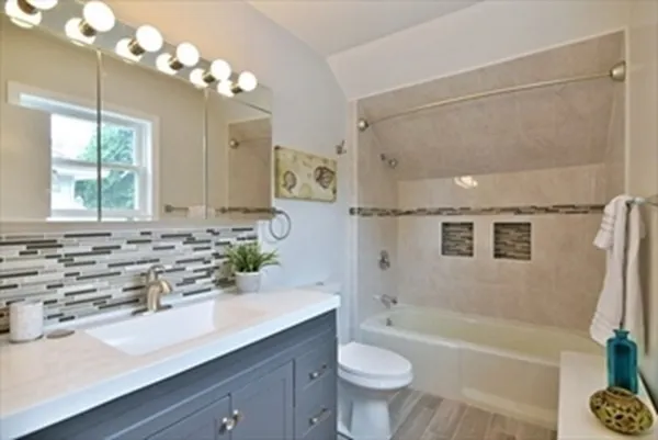 a bathroom with a bathtub a sink and a large mirror