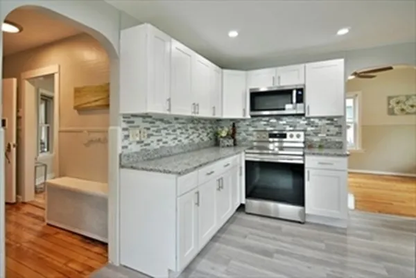 a kitchen with stainless steel appliances granite countertop a stove top oven a sink and a refrigerator
