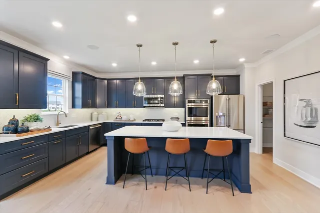a kitchen with kitchen island granite countertop wooden cabinets and refrigerator